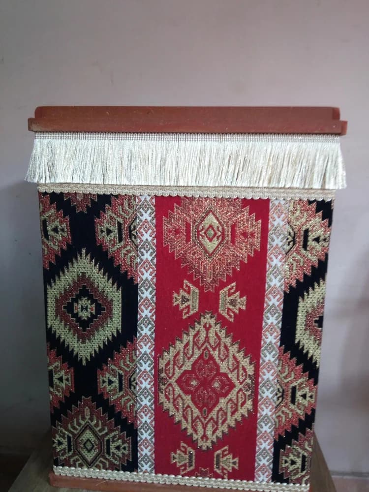 Kilim Desenli Kare Kova – Kilim desenli kare kova, köşeli gövdesi ve püsküllü üst kenarıyla görülür