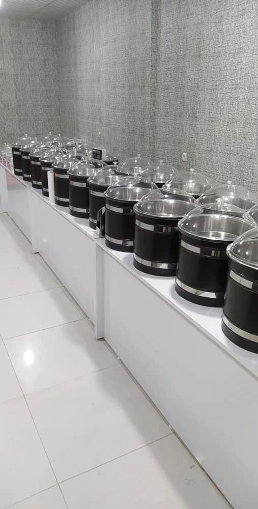 Çerez Krom Kova – Krom çerez kovası kaydının fotoğrafında mağaza tezgâhına yerleştirilmiş birden fazla silindirik hazne bulunur